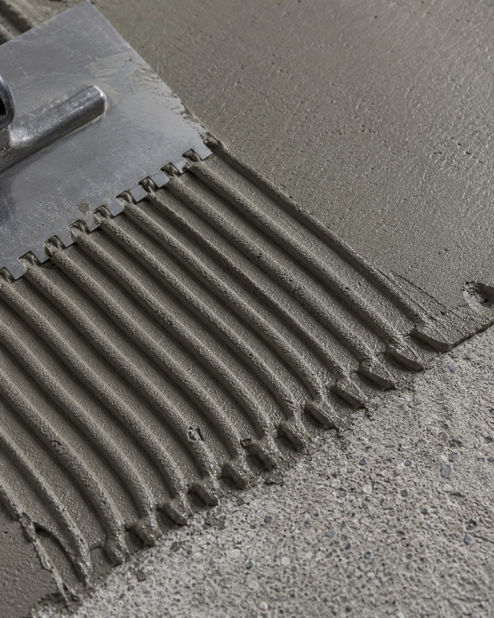 Zaprawa klejąca rozprowadzona pacą zębatą na betonowym podkładzie